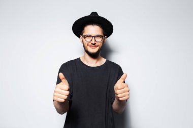 Siyah şapkalı genç ve yakışıklı bir adamın stüdyo portresi..