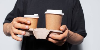 Erkek ellerinin kağıt bardaklarla kağıt tutacağı yakın plan..