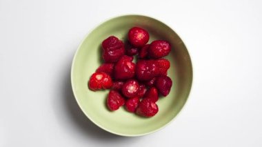 Hareket konseptini durdur. Çilekli yeşil kâse manzarası. Beyaz arkaplan.