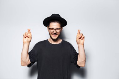 Mutlu genç adamın portresi gri arka planda gözleri kapalı bir şekilde kesişiyor..