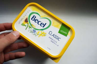 Erkek el ele vejetaryen tereyağı paketinin üst görüntüsü Becel. Moldova, Chisinau - 23 Mayıs 2022.