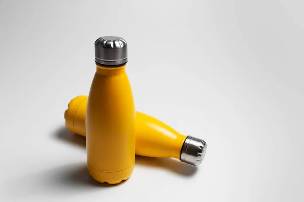 Primer Plano Pequeñas Botellas Agua Termo Amarillas Sobre Fondo Gris — Foto de Stock