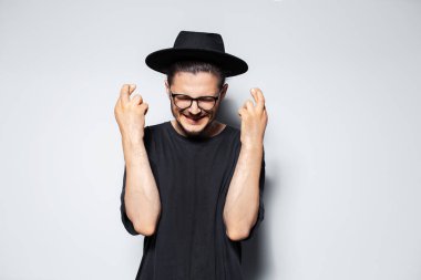 Mutluluğun portresi Gri arka planda gözleri kapalı bir şekilde dua eder.