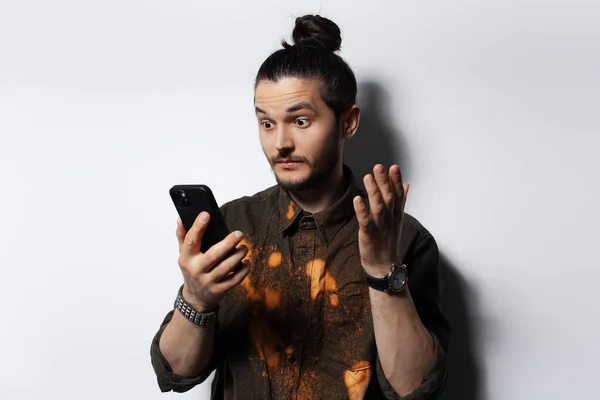 Surpreendido Jovem Hipster Olhando Smartphone Fundo Branco — Fotografia de Stock