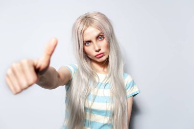 Beyaz arka planda kendine güvenen sarışın kızın portresi..