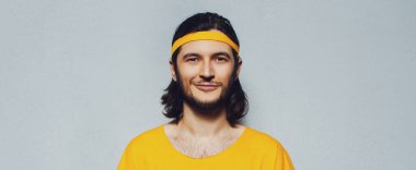 Gri arka planda sarı elbiseli neşeli genç adam. Panoramik pankart görünümü.