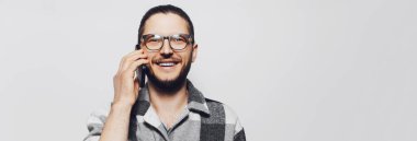 Ekose gömlekli bir gencin akıllı telefondaki portresi. Panoramik pankart.