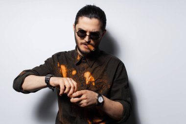 Beyaz arka planda purosu olan genç bir adamın yakın çekim portresi..