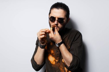 Beyaz arka planda purosu olan genç bir adamın yakın çekim portresi..