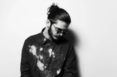 Black and white portrait of young man, wearing round sunglasses.
