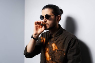 Beyaz arka planda purosu olan genç bir adamın yakın çekim portresi..