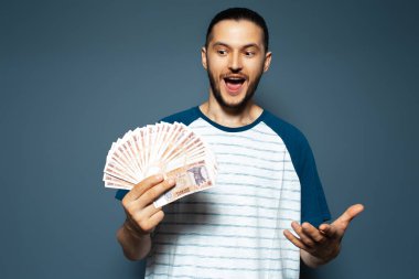 Mutluluğun portresi. Elinde para tutan genç adam, Moldova leu banknotları, mavi üzerine..
