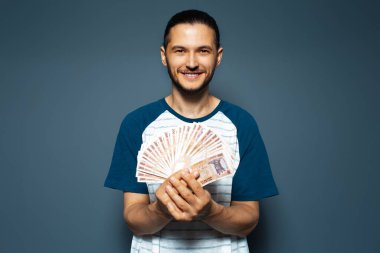 Gülümseyen adamın stüdyo portresi, elinde para, bir deste banknot, Moldovan leu.
