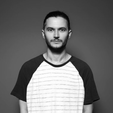 Grinin stüdyo arka planında siyah beyaz insan portresi.