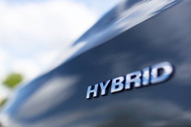 Close-up of Hybrid icon on car body. Environment concept. Ecological auto.