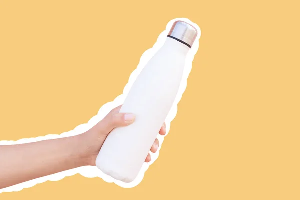 Reusable thermo water bottle in hand, isolated with white contour on yellow.