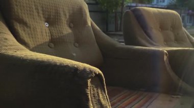 The old abandoned armchairs outside at sunset.