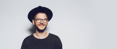 Beyaz arka planda gülümseyen genç bir adamın panoramik pankart portresi.