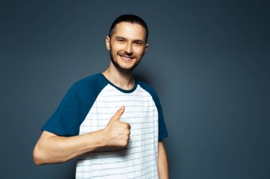 Mavi arka planda gülümseyen adamın stüdyo portresi..