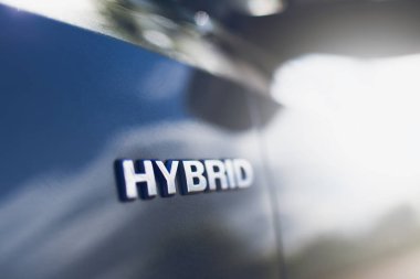 Araba gövdesinde Melez simgesine yakın çekim. Çevre kavramı.