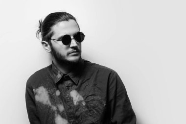 Black and white studio portrait of young handsome man, wearing shades.