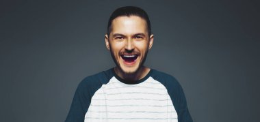 Studio portrait of young confident happy man. Panoramic banner view.