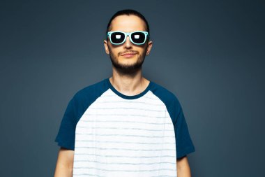 Studio portrait of young handsome man, wearing sunglasses.