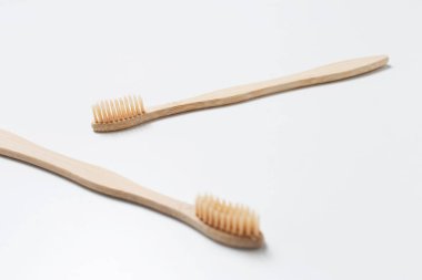 Close-up of two bamboo toothbrushes on isolated white background. Health care concept.