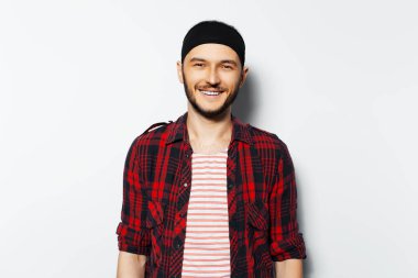 Studio portrait of young smiling man on white background. Wearing red casual clothes and black head band. Happiness guy.