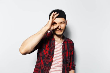 Studio portrait of young guy showing ok gesture on white background.