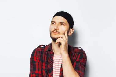 Studio portrait of young thoughtful man looking up on white background.