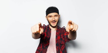 Studio portrait of young happy man pointing index finger on camera, on you. Background of white color. Panoramic banner view.