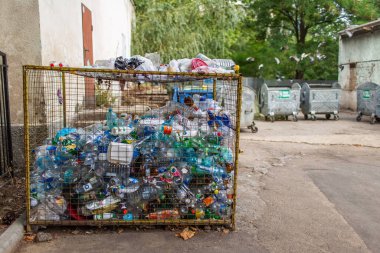 Plastic garbage in special container, big metal basket.