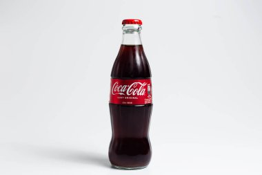 Close-up of glass bottle of Coca Cola, on white studio background. Moldova, Chisinau - 10 august 2022.