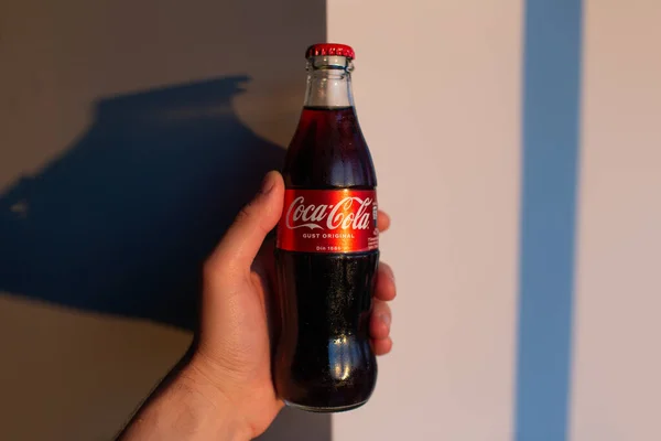 Close Male Hand Holding Glass Bottle Coca Cola Background Grey — Fotografia de Stock