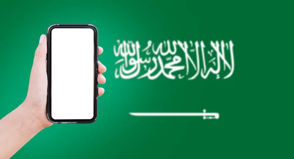 Чоловік Тримає Смартфон Порожнім Екраном Задньому Плані Розмитий Прапор Саудівської — стокове фото