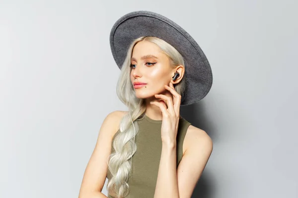 Studio Πορτρέτο Του Όμορφη Ξανθιά Κοπέλα Αγγίζει Ασύρματα Ακουστικά Ακούγοντας — Φωτογραφία Αρχείου