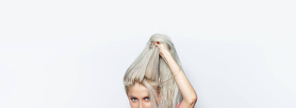 Студийный портрет молодой красивой девушки, держащей светлые волосы на белом фоне, панорамный баннер.