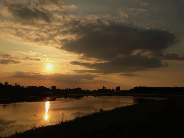 Sunset on the river with cloudy sky and reflection in water