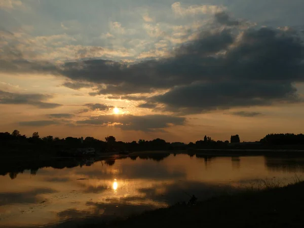 Sunset on the river with cloudy sky and reflection in water