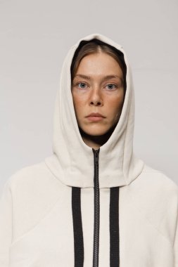 Stüdyoda şık ve güzel bir kız beton duvara karşı poz veriyor.