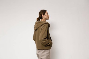 Stüdyoda şık ve güzel bir kız beton duvara karşı poz veriyor.