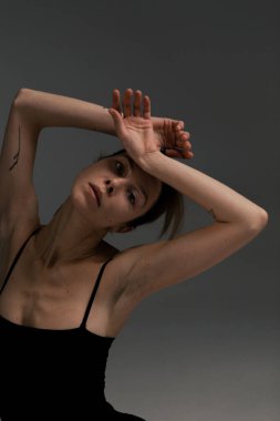 Güzel ve zayıf bir kız beyaz bir arka planda ısınıyor.