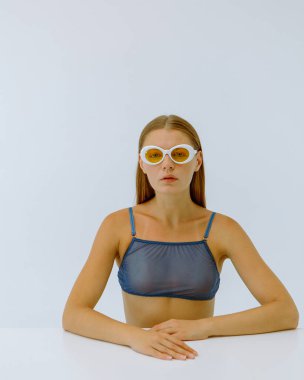 Beyaz arka planda sarı gözlüklü bir kızın sanat portresi. 