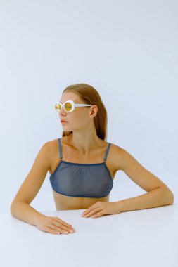 Beyaz arka planda sarı gözlüklü bir kızın sanat portresi. 