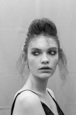 Saçları ve makyajı olan güzel bir kızın geçmişe dönük portresi.