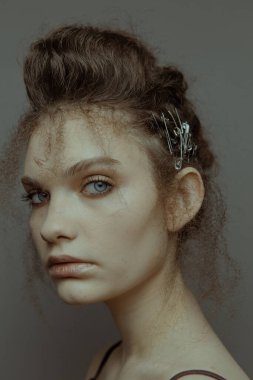 Saçları ve makyajı olan güzel bir kızın geçmişe dönük portresi.