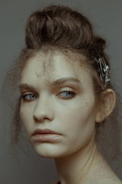 Saçları ve makyajı olan güzel bir kızın geçmişe dönük portresi.