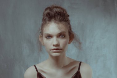 Saçları ve makyajı olan güzel bir kızın geçmişe dönük portresi.