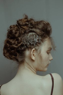 Saçları ve makyajı olan güzel bir kızın geçmişe dönük portresi.